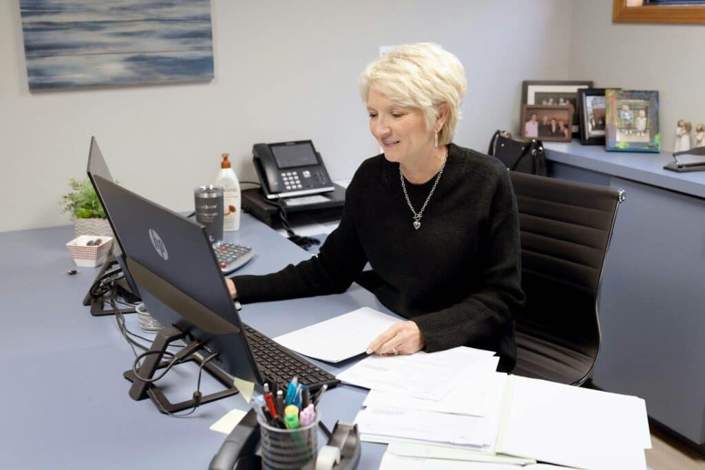 Woman works on laptop at her office desk.